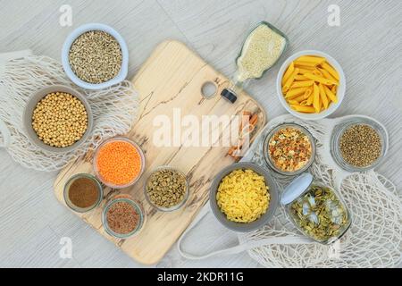 Bio prodotti biologici in negozio zero rifiuti. Vari prodotti agricoli in vasetti di vetro su sfondo di legno chiaro. Spazio di copia. Vista dall'alto. Foto Stock