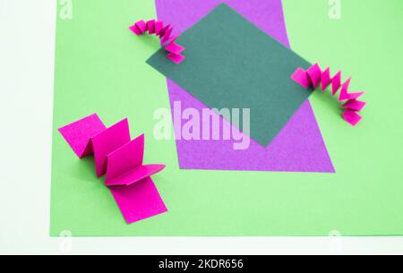 Sfondo astratto in verde, rosa e viola con 3D elementi in carta, motivo a zig zag . Come sfondo per i prodotti pubblicitari, spazio copia. Foto Stock