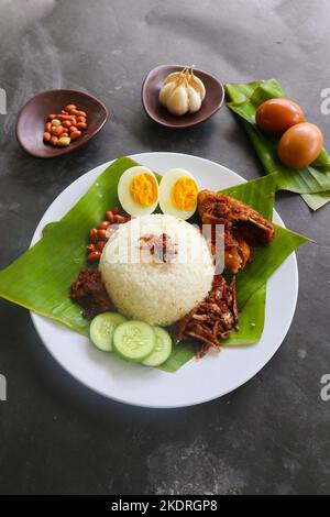 nasi lemak, è tradizionale malese fatto uova sode, fagioli, acciughe, salsa di peperoncino, cetriolo. da piatto servito su una foglia di banana Foto Stock