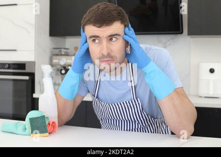 Un uomo che pulisce la cucina, ha lavorato troppo Foto Stock