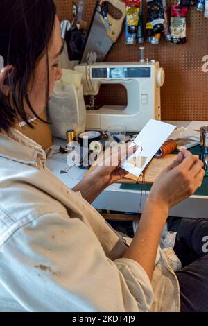 pittura su tela bianca, donna ispanica con pennelli e pittura ad olio Foto Stock