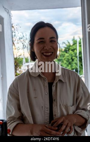 pittura su tela bianca, donna ispanica con pennelli e pittura ad olio Foto Stock