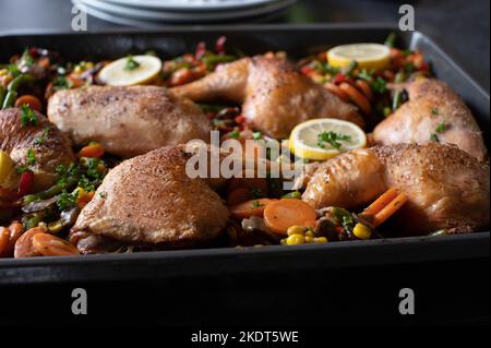 Cosce di pollo arrosto con mix di verdure francesi su un vassoio da forno. Pasto sano a basso contenuto di carb Foto Stock
