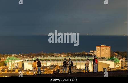 Calton Hill, Edimburgo, Scozia, Regno Unito, 8th novembre 2022. UK Weather: Sole e nuvole con i turisti che scattano foto della vista attraverso il Firth of Forth con lo stadio Hibernian Football Club sullo sfondo e l'Isola di Maggio illuminata in lontananza. Credit: Sally Anderson/Alamy Live News Foto Stock