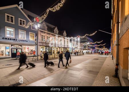 Storgata - la principale via dello shopping a Tromso, Norvegia. Di notte in inverno con decorazioni festive Foto Stock