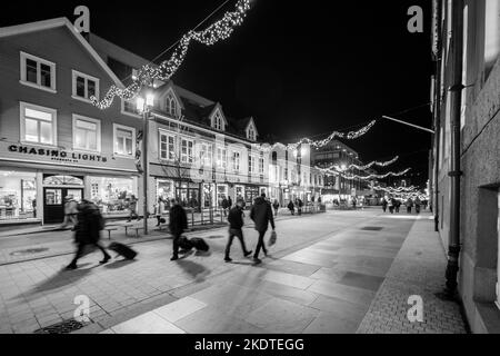 Storgata - la principale via dello shopping a Tromso, Norvegia. Di notte in inverno con decorazioni festive Foto Stock