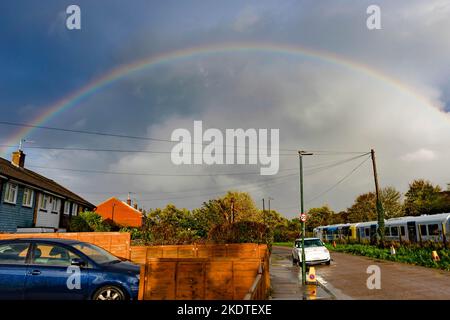 Un arcobaleno si forma su cieli oscuri a Twickenham, Londra, dopo una pesante doccia a pioggia. Il Regno Unito ha vissuto la pioggia e i venti alti, con un avvertimento di tempo giallo emesso per parti del paese. Foto Stock