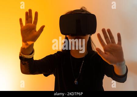 una bambina stupita indossa occhiali vr utilizzando la tecnologia per l'istruzione nella realtà virtuale, nel mondo virtuale. Banner di bambina con realtà virtuale vr Foto Stock