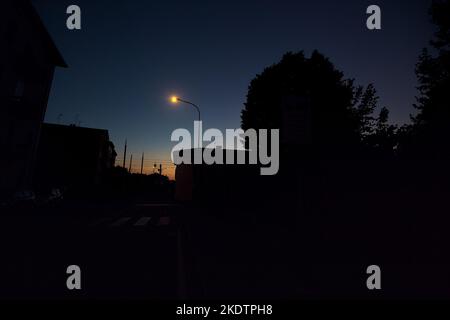 Attraversamento ferroviario in una città al crepuscolo Foto Stock