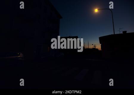 Attraversamento ferroviario in una città al crepuscolo Foto Stock