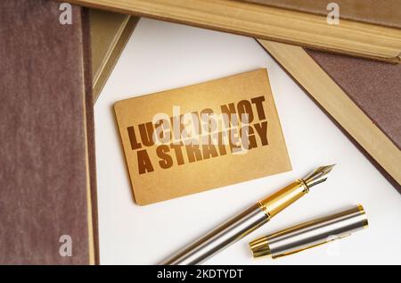 Concetto di istruzione e business. Accanto ai libri si trova una penna e un segno con l'iscrizione - la fortuna non è una strategia Foto Stock