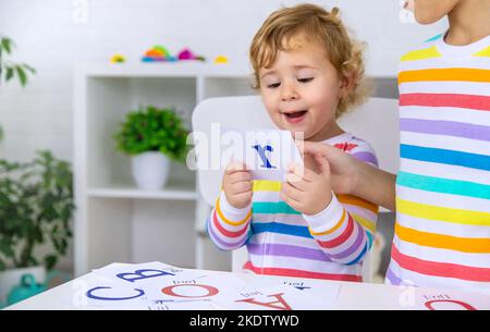 Il bambino impara le lettere inglesi. Messa a fuoco selettiva. Bambino. Foto Stock