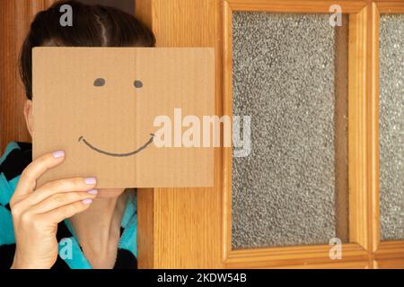 Ragazza che tiene carta di cartone con un sorriso allegro, buon umore e gioia Foto Stock