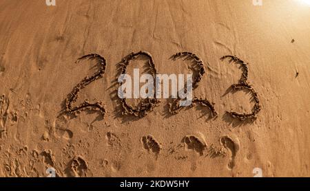 Capodanno tropicale 2023 scritto in sabbia dorata sulla spiaggia Foto Stock