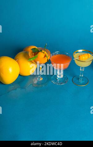 tre cocktail di agrumi, bevande su sfondo blu Foto Stock