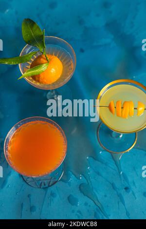 tre cocktail di agrumi, bevande su sfondo blu Foto Stock