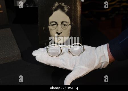 Un paio di occhiali tondi in tonalità oro con filo metallico abbinato a foto, di proprietà e indossati da John Lennon, in mostra all'Hard Rock Cafe Times Square il 08 novembre 20 Foto Stock