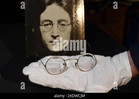 Un paio di occhiali tondi in tonalità oro con filo metallico abbinato a foto, di proprietà e indossati da John Lennon, in mostra all'Hard Rock Cafe Times Square il 08 novembre 20 Foto Stock