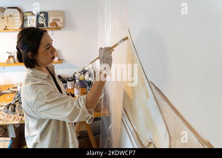 pittura su tela bianca, donna ispanica con pennelli e pittura ad olio Foto Stock