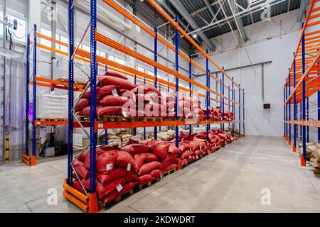 Borse con produzione su scaffali in magazzino. Sacchetti con chicchi di caffè o zucchero o altro Foto Stock