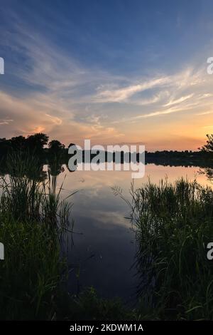 Meraviglioso, colorato paesaggio estivo. Tramonto nel bel cielo sul lago. Foto Stock
