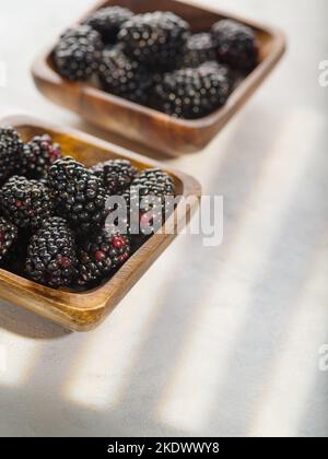 Su fondo bianco, more mature in ciotole. Prodotto vitaminico utile, pronto all'uso. Stile di vita sano. Dessert. Non ci sono persone nella foto. Foto Stock