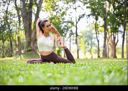 Ritratto di splendida giovane donna che pratica yoga all'aperto. Foto Stock