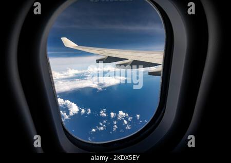 Illuminatore con ala di aeroplano sopra la superficie piana delle nuvole lanuginose con la luce solare morbida della sera Foto Stock