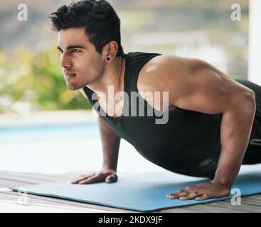 Una volta che vedete i risultati, diventa una dipendenza. Un giovane che fa i pushups durante il suo workout nel paese. Foto Stock