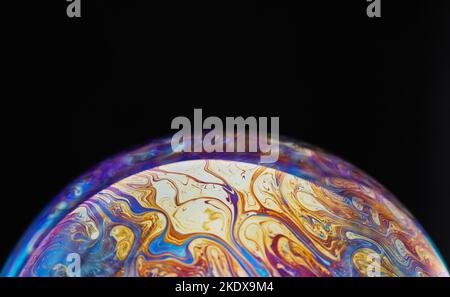 Spazio di realtà virtuale con un pianeta psichedelico astratto multicolore. Closeup bolla di sapone come un pianeta alieno su sfondo nero Foto Stock