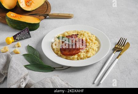 Risotto di zucca con pancetta e salvia in piatto bianco, spazio copia Foto Stock