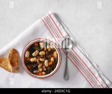 Zuppa invernale con diverse verdure, fagioli, kale. Tipica zuppa toscana, ribollita. Cucina italiana. Vista dall'alto, spazio per fotocopie Foto Stock