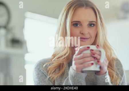 Inizio sempre la giornata con una forte cupola. Ritratto di una giovane donna attraente godendo una tazza di caffè a casa. Foto Stock
