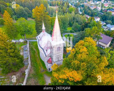 Chiesa neorinascimentale di San Pietro e Paolo al tramonto del sole d'autunno. Tanvald, Repubblica Ceca. Vista aerea dal drone. Foto Stock