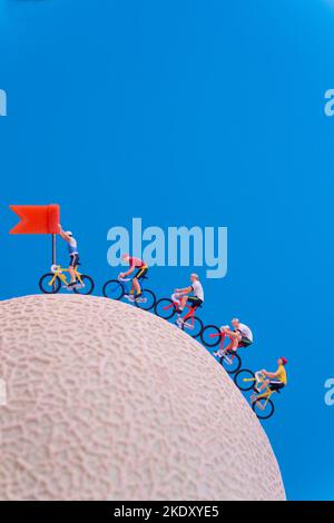 Giocattoli in miniatura - ciclista stradale che si avvicina alla linea di arrivo, concetto di celebrazione. Foto Stock