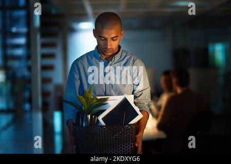 Così questa è la fine allora... un giovane uomo d'affari che tiene una scatola dei suoi possessi dopo essere stato licenziato dal suo lavoro. Foto Stock