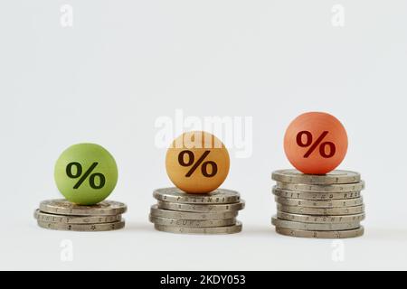 Sfera di legno con simbolo di percentuale su pila di moneta - concetto di finanza e tasso di interesse di crescita percentuale Foto Stock