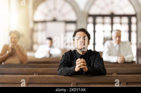 Preghiera, religiosi e giovani in chiesa con congregazione, fedeli e mani insieme. Religione, maschio e adorazione nel tabernacolo come guida Foto Stock