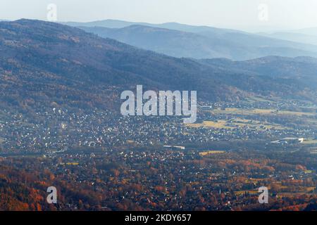 Una bella vista verso il piccolo Beskids e il villaggio di Wilkowice dalla torre di osservazione sul monte Szyndzielnia. Autunno mattina. Pola Foto Stock