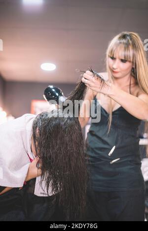 Capelli del cliente che asciuga stylist nel salone di bellezza Foto Stock