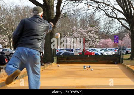 Una persona lancia una palla bocce in un campo bocce all'aperto fuori dal Cherry Blossom Welcome Center nel Branch Brook Park, Belleville, New Jersey. Foto Stock