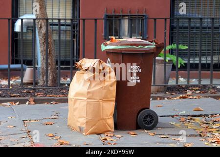 Un bidone marrone per gli scarti alimentari e i rifiuti di iarda impostato sul marciapiede per la raccolta di servizi igienici a Brooklyn, New York City. Il compostaggio di Curbside è un sanitation di NYC ... Foto Stock