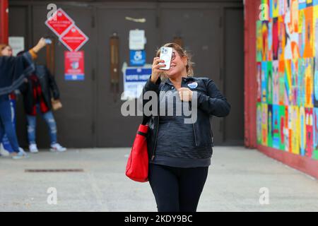 Persone che scattano selfie con i loro adesivi "ho votato nella città di New York" fuori da un seggio a Manhattan Chinatown, New York, 8 novembre 2022. Foto Stock