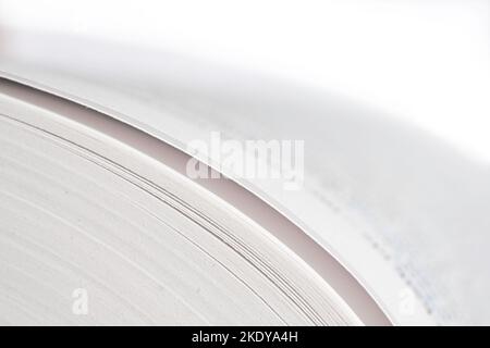 Pagine nella parte sinistra di un libro aperto, profondità di campo ridotta su sfondo bianco. Testo sfocato Foto Stock
