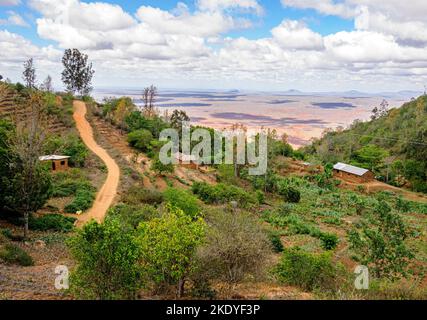 Case del villaggio e pista alta nelle colline di Sagalla che si affaccia sulla pianura di Ndara vicino voi in Kenya Foto Stock