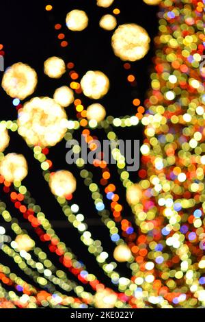 Albero di Natale di Capodanno decorato con luminose ghirlande multicolore e illuminazione notturna. Albero di Natale con luci lampeggianti. Sfondo sfocato. Capodanno vacanze di Natale. Foto Stock