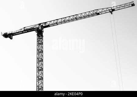 Una foto in scala di grigi di una gru in cantiere Foto Stock