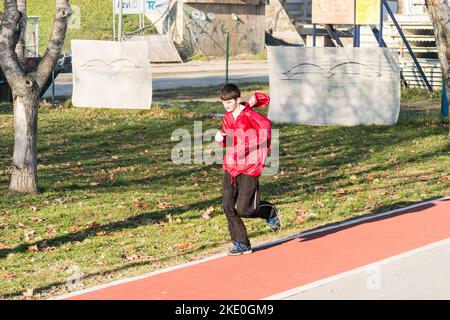 Novi Sad, Serbia. Dicembre 22, 2013. Un giovane Signore che corre ricreativamente. Un giovane Signore corre ricreativamente, sul sentiero sabbioso sulle rive Foto Stock