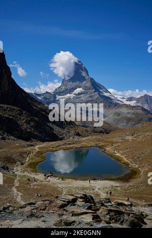Uno scatto verticale di un piccolo lago con l'enorme montagna del Cervino sullo sfondo Foto Stock
