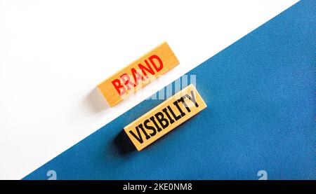 Simbolo di visibilità del marchio. Parole chiave visibilità del marchio su blocchi di legno. Splendido sfondo bianco e blu. Branding aziendale e visibilità del marchio Foto Stock